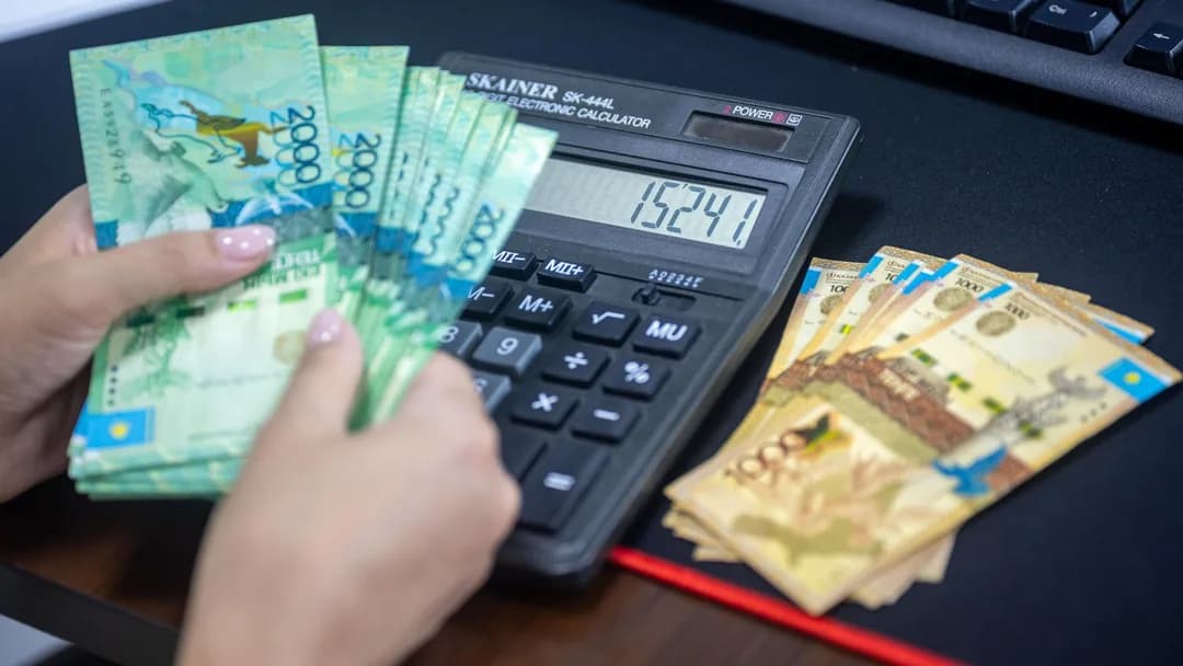 Mãos fazendo contas com calculadora e dinheiro na mesa
