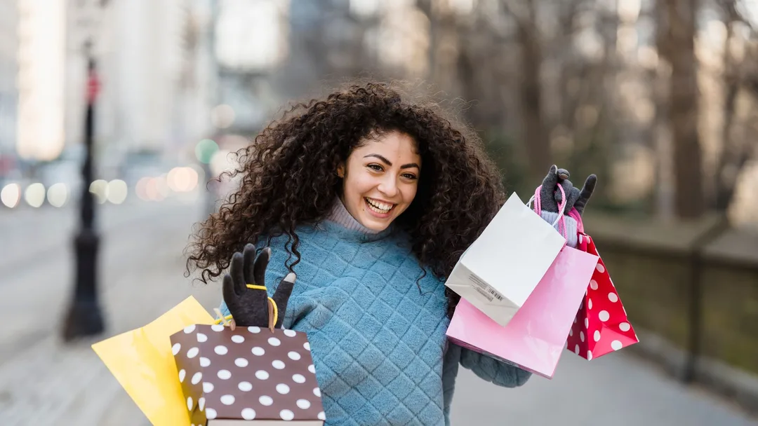 Cliente feliz segurando sacolas de presente na rua