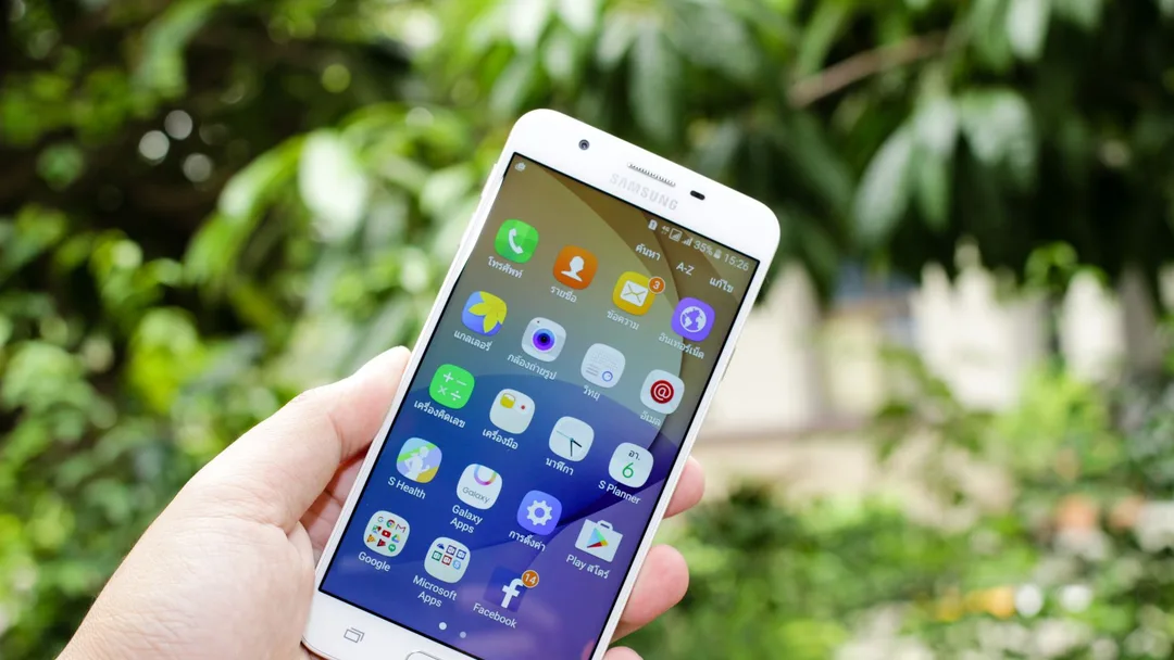 Mão segurando um celular com vários aplicativos
