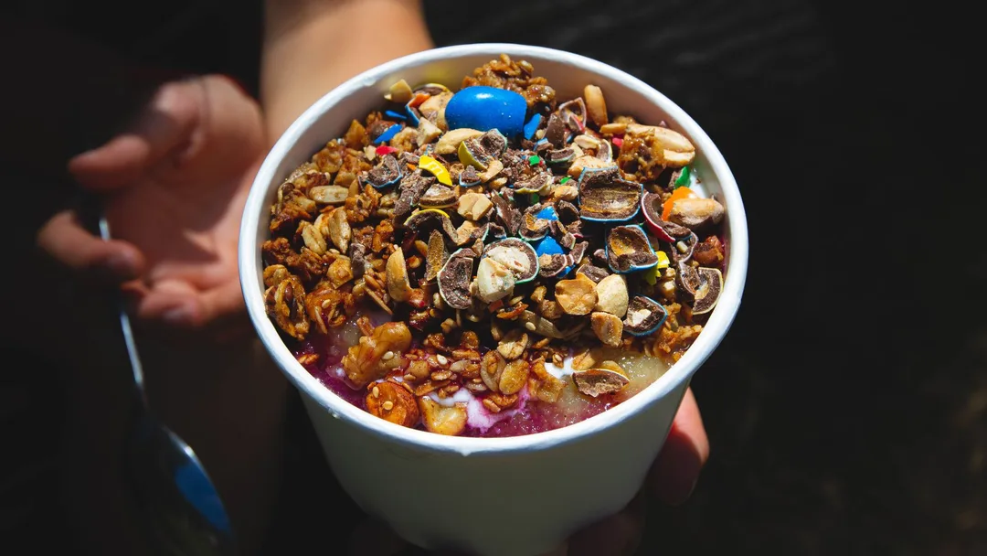 Copo de açaí com granola e complementos servido na loja