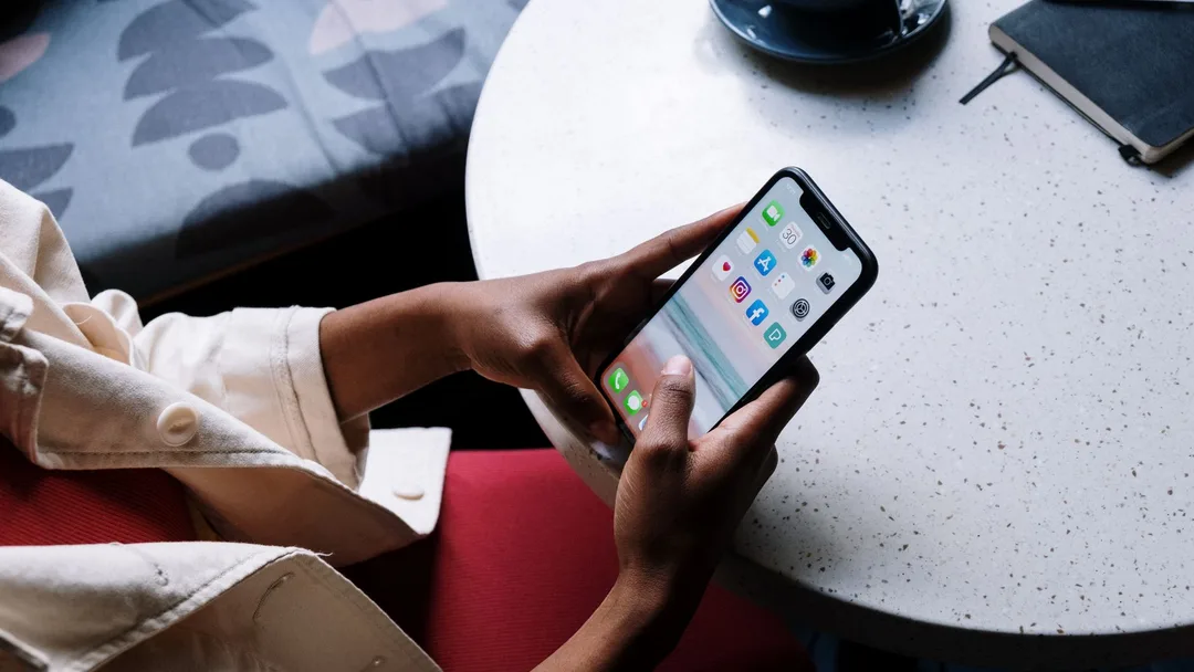 Cliente usando o aplicativo no celular numa mesa de café